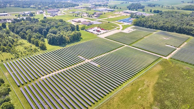 Image of High up view of solar farm in grassy field on bright summer day