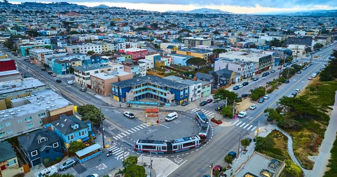 Image of Urban San Francisco with endless residential housing and city buses in circle path on road aerial