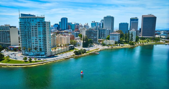 Image of Aerial single sailboat on Lake Merritt with view of downtown Oakland buildings in California