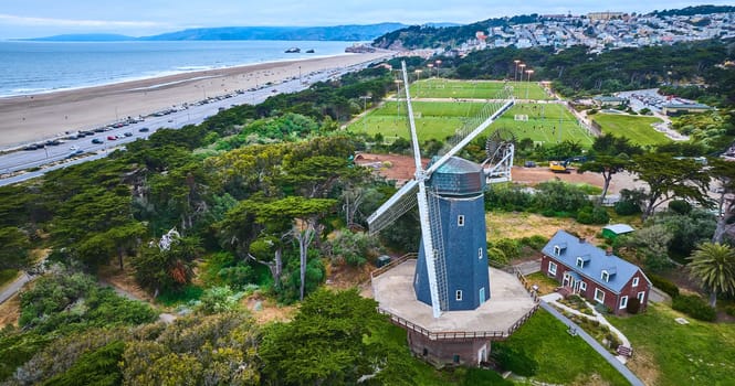 Image of Murphy windmill beside small home and active soccer fields with city and ocean aerial