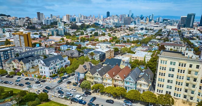 Image of Aerial The Painted Ladies houses with wide view of San Francisco city buildings and skyscrapers