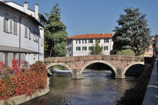 ancient bridge over a derivation of lambro river in monza city center, shot in fall