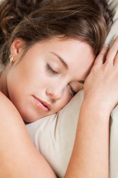 Pretty young woman sleeps in her bed
