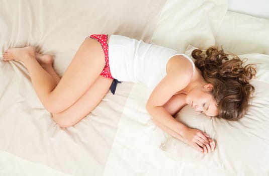 Pretty young woman sleeps in her bed