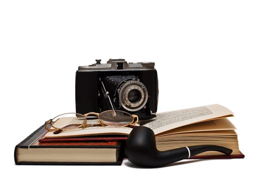 Old books and a pair of glasses isolated over a white background.