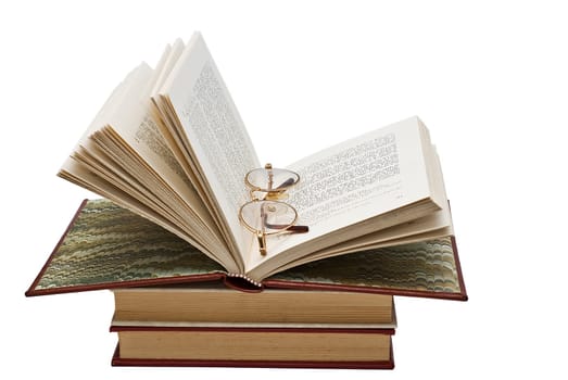 Old books and a pair of glasses isolated over a white background.