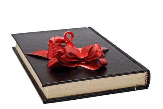 A red ribbon on an old book isolated over a white background.