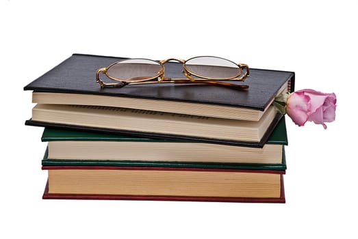 Old books and a pair of glasses isolated over a white background.