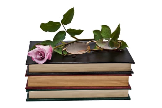 Old books and a pair of glasses isolated over a white background.