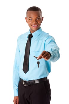 Handsome happy corporate business man realtor handing over keys to new house, dressed in blue shirt and black tie, isolated. Selling concept.