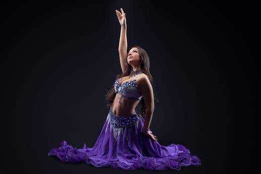 beauty young girl dance in purple veil arabic style costume in dark