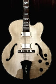 Ivory electric guitar against black background