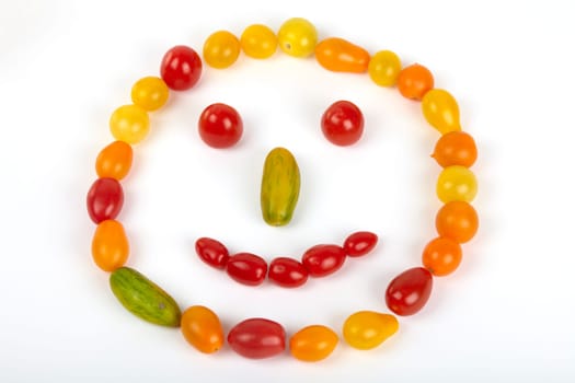 Smiley face made of small fresh organic tomatoes seen from above. Smiley face made of small fresh organic tomatoes out,seen from above.