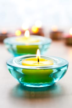 Close-up of yellow candles in blue glass holders