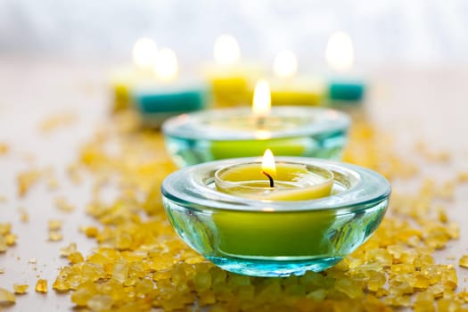 Close-up of blue and yellow candles with yellow bath salt