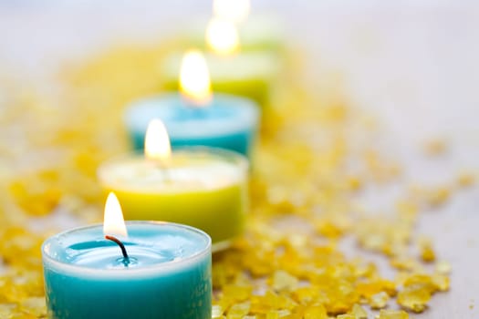 Close-up of blue and yellow candles with yellow bath salt