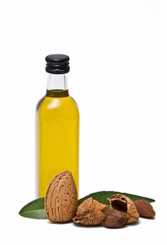 Almonds and a bottle of almond oil isolated over a white background.