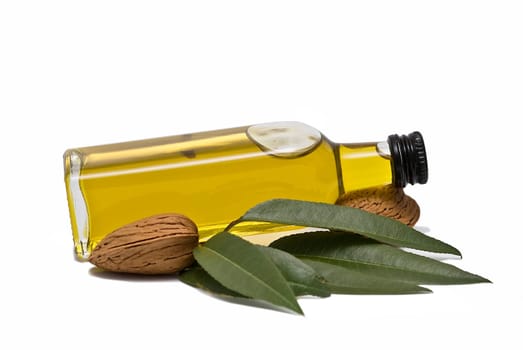 Almonds and a bottle of almond oil isolated over a white background.