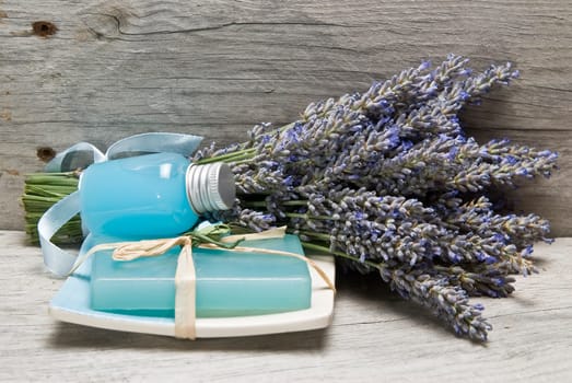 Lavender and some hygiene items made of lavender on an old wooden shelf.