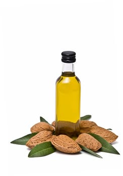 Almonds and a bottle of almond oil isolated over a white background.