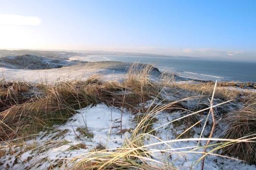 snow covered links golf course in ireland in winter with sea background