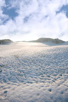 snow covered links golf course in ireland in winter with footprints