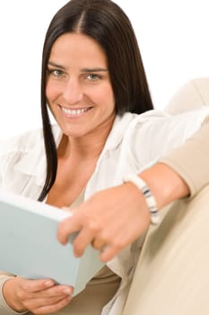 Happy mid-aged woman with book sitting on couch