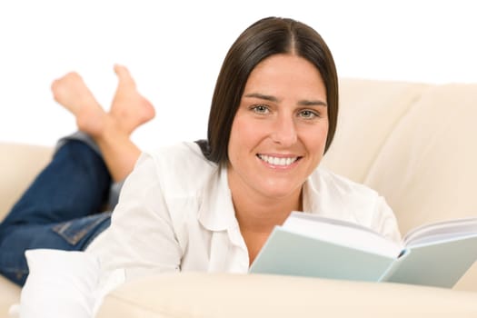 Attractive mid-aged woman read book on sofa in lounge