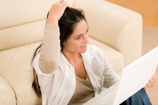 Attractive woman with laptop sitting by couch relax home