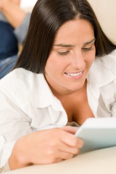 Smiling mid-aged woman read book on sofa in lounge