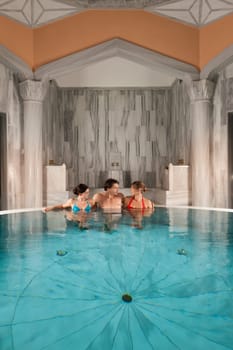 Three friends in the indoor pool or thermal bath