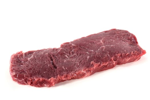 a fresh,raw rump steak against a white background