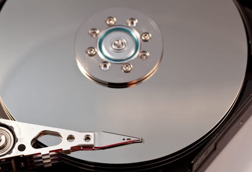 Magnetic disc inside a computer hd unit showing mirror surface of the magnetic discs and read write head