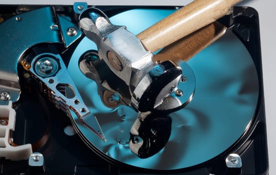 Magnetic disc inside a computer hd unit showing damage to the mirror surface of the magnetic discs and read write head from a hammer