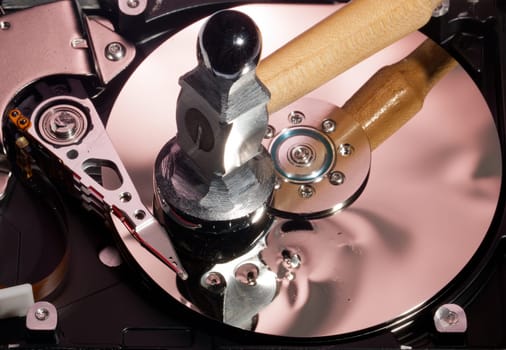 Magnetic disc inside a computer hd unit showing damage to the mirror surface of the magnetic discs and read write head from a hammer