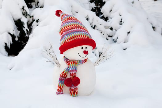 Snowman decorated with scarf and hood in winter