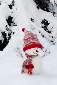 Snowman decorated with scarf and hood in winter