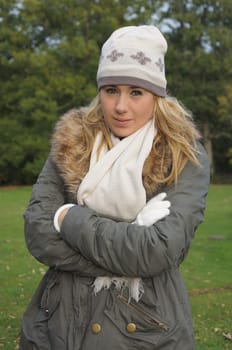 Pretty teenage girl wearing hat, scarf and gloves enjoying a walk in the countryside