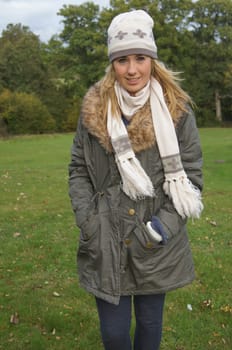 Pretty teenage girl wearing hat, scarf and gloves enjoying a walk in the countryside