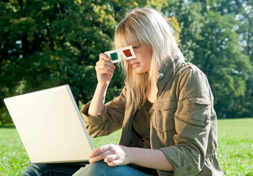 Young woman with 3d glasses and laptop on a meadow