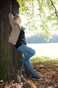 Young woman standing at a tree