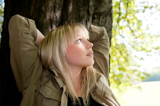 Young woman standing at a tree