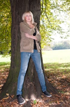 Young woman standing at a tree