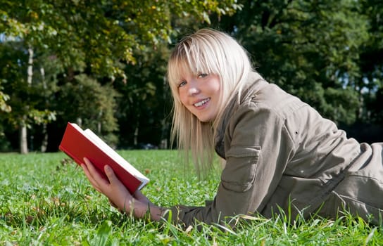 Young woman reading book in a meadow