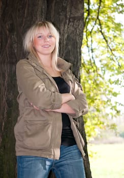 Young woman standing at a tree