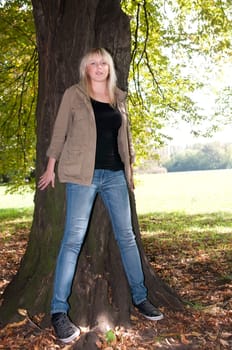 Young woman standing at a tree