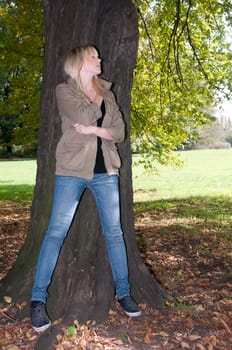 Young woman standing at a tree