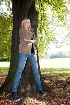 Young woman standing at a tree