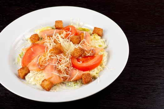 Salad of lettuce, chinese cabbage, tomato, garlic rusk, parmesan cheese, sauce and smoked salmon filet