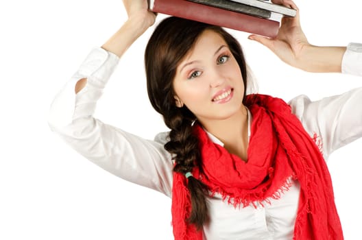 Young student girl with her books in hand at head, smiling and looking at the camera
